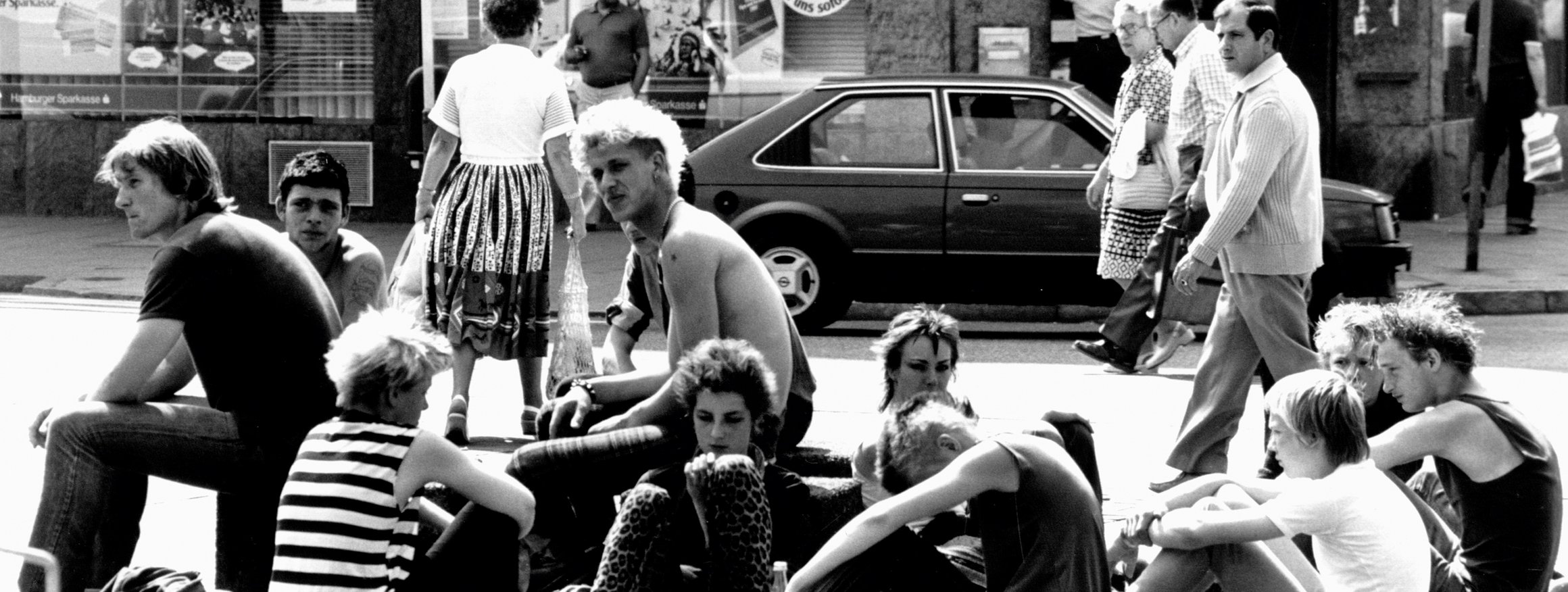 Eine Gruppe von Punkern sitzen auf dem Spritzenplatz in Hamburg 1982 auf der Straße