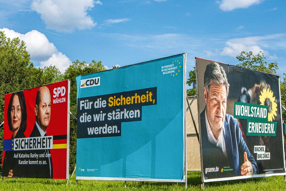 Große Wahlplakate von verschiedenen Parteien an der Straßenseite