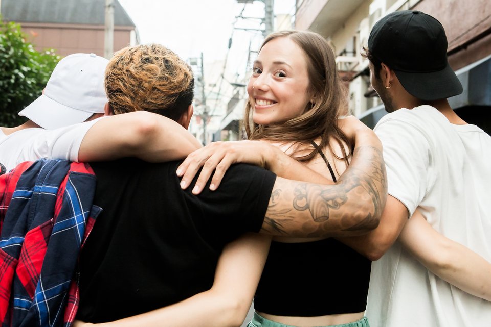 Foto zeigt eine junge Frau, die mit Freunden unterwegs ist