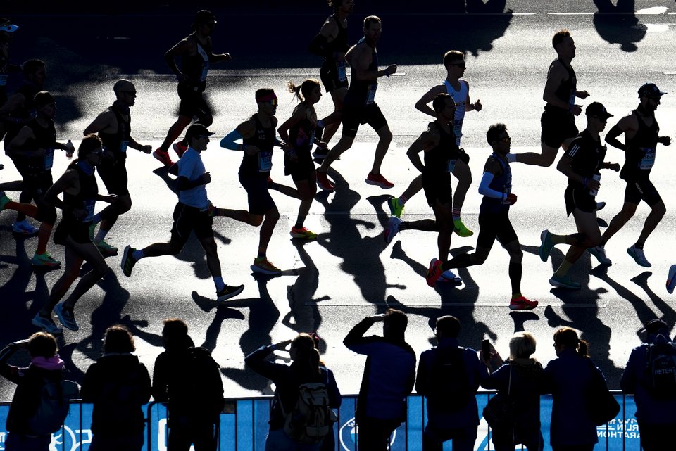 Teilnehmer eines Marathons laufen auf einer Straße entlang