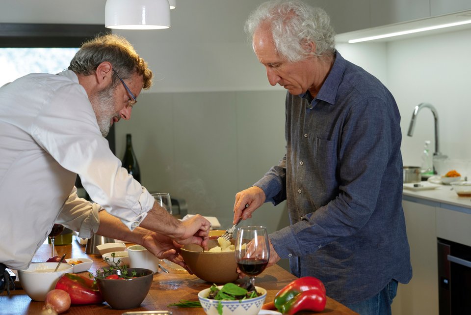 Zwei ältere Männer stehen in der Küche bereiten gemeinsam ein Essen vor