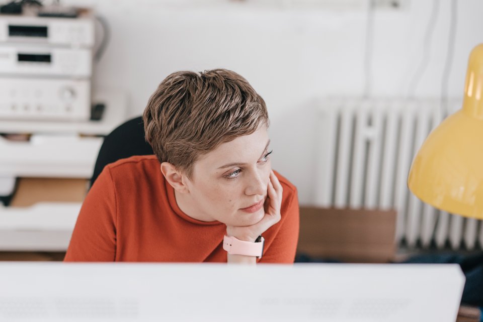 Eine Büroangestellte sitzt gelangweilt an ihrem Arbeitsplatz