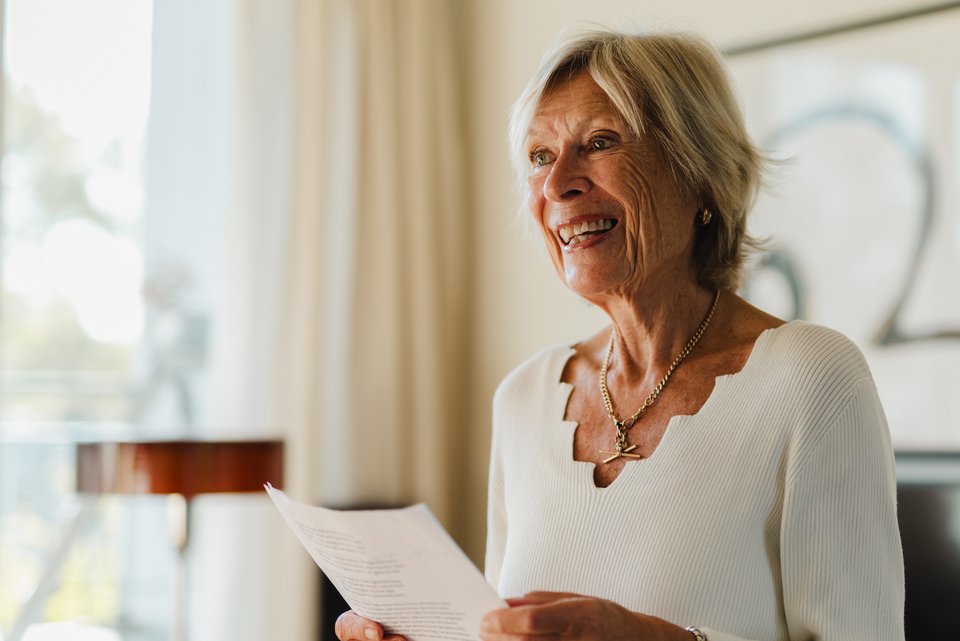 Lola Plass steht mit einem Liedertext in der Hand da und singt